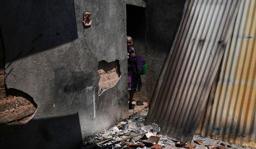 Anastasia Cabrera walks through the ruins of her home after armed attacks by local criminal groups forced dozens of residents to flee, in Tula, Mexico, Friday, May 15, 2026. (AP Photo/Marco Ugarte)