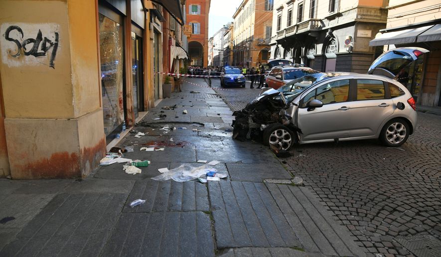 Blood is seen next to a destroyed car on a street of Modena, Italy, Saturday, May 16, 2026. (Lapresse via AP)