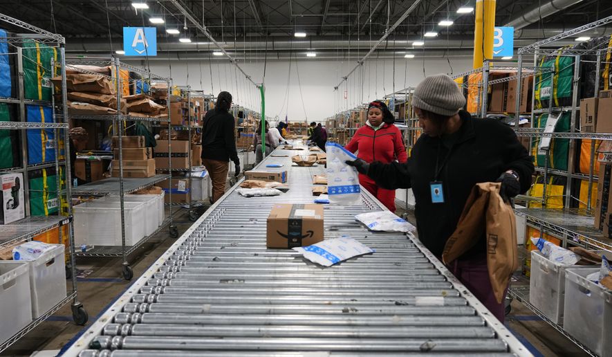 Amazon employees sort packages at a last-mile delivery center in Seaford, Del., Wednesday, Jan. 21, 2026. (AP Photo/Stephanie Scarbrough)