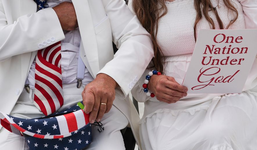 Dorothea and Billy Ohlandt, from North Carolina, arrive at Rededicate 250, a mostly conservative Christian prayer gathering in honor of the United States' 250th anniversary, on the National Mall, Sunday, May 17, 2026, in Washington. (AP Photo/Julia Demaree Nikhinson)