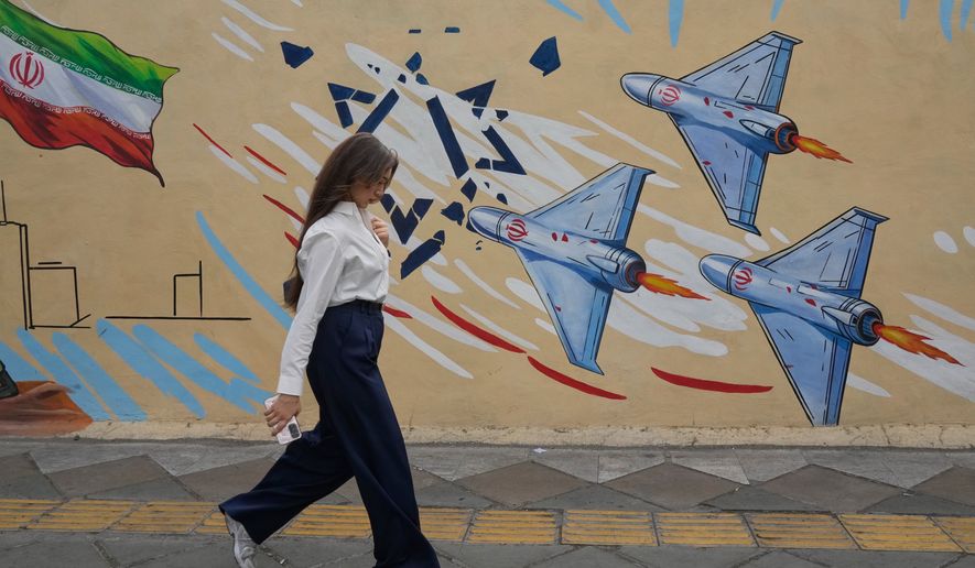 A woman walks past an anti-Israel mural in Tehran, Iran, Sunday, May 17, 2026. (AP Photo/Vahid Salemi)