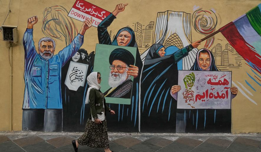 A woman walks past a pro-government mural in downtown Tehran, Iran, Sunday, May 17, 2026. (AP Photo/Vahid Salemi)