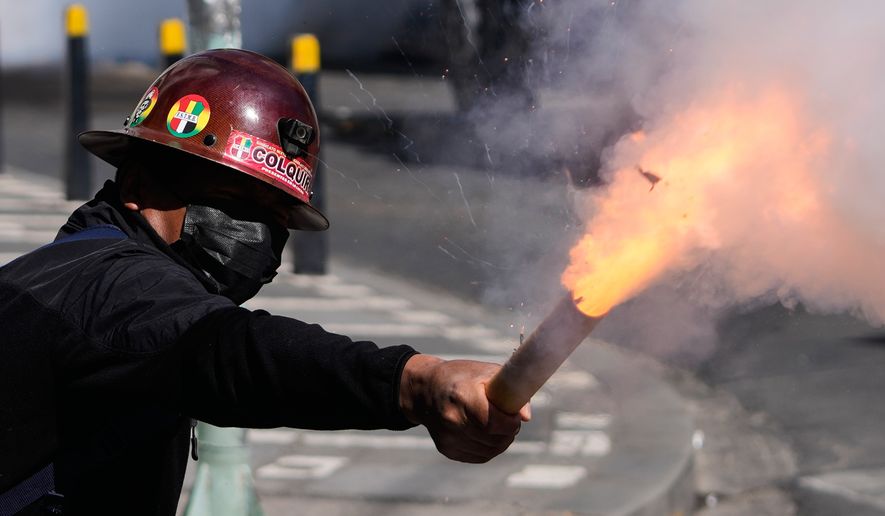 A miner launches a firecracker at police during an anti-government protest in La Paz, Bolivia, Monday, May 18, 2026. (AP Photo/Juan Karita)