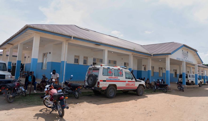 People wait near an ambulance at a hospital in Bunia, Congo, Sunday, May 17, 2026. (AP Photo/ Dirole Lotsima Dieudonne)