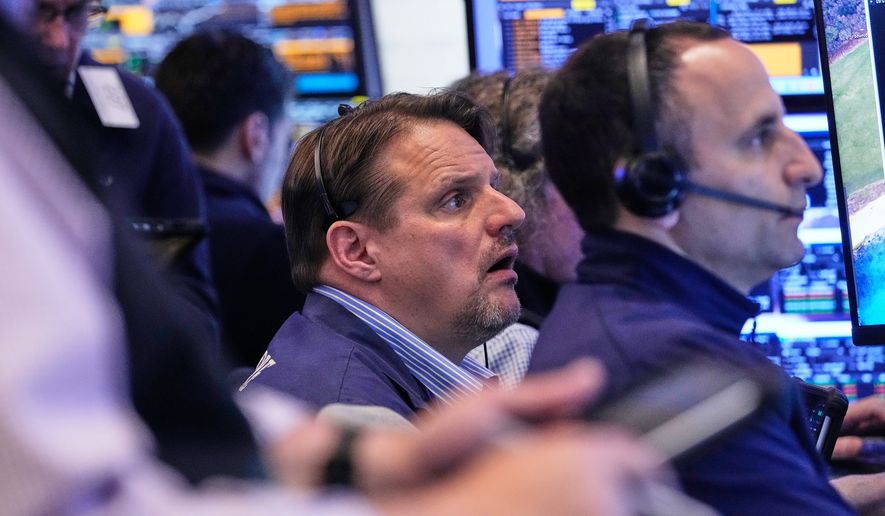 Trader Michael Milano, center, works with colleagues on the floor of the New York Stock Exchange, Wednesday, May 13, 2026. (AP Photo/Richard Drew)