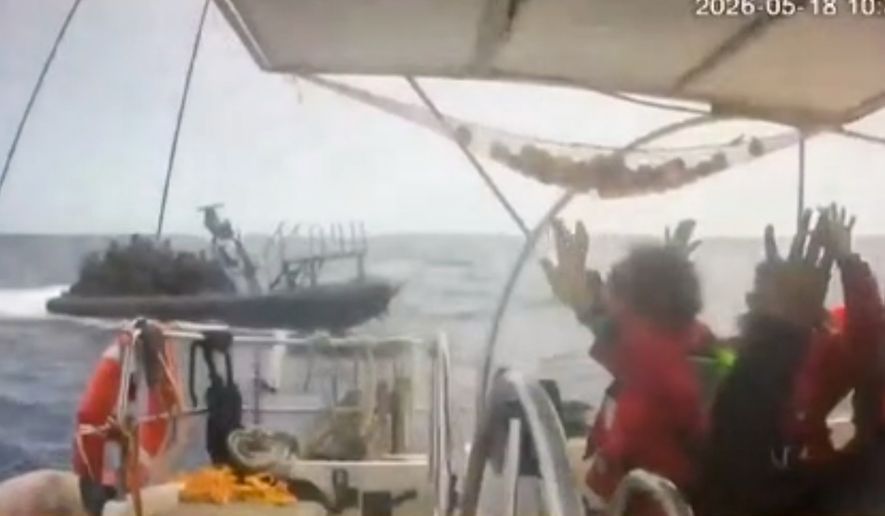 This grab from CCTV footage shows activists aboard a flotilla boat with their hands in the air as a boat approaches one of more than 50 vessels that departed from the port of Marmaris, Turkey, last week in what organizers of the Global Sumud Flotilla described as the final leg of their planned journey to Gaza's shores, in international waters Monday, May 18, 2026. (Global Sumud Flotilla via AP)