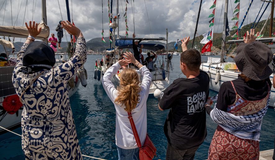 People wave to boats belonging to the Global Sumud Flotilla, carrying activists and humanitarian aid, depart for Gaza from the port of Marmaris, Turkey, Thursday, May 14, 2026, in an attempt to break the Israeli naval blockade. (AP Photo/Murat Kocabas)