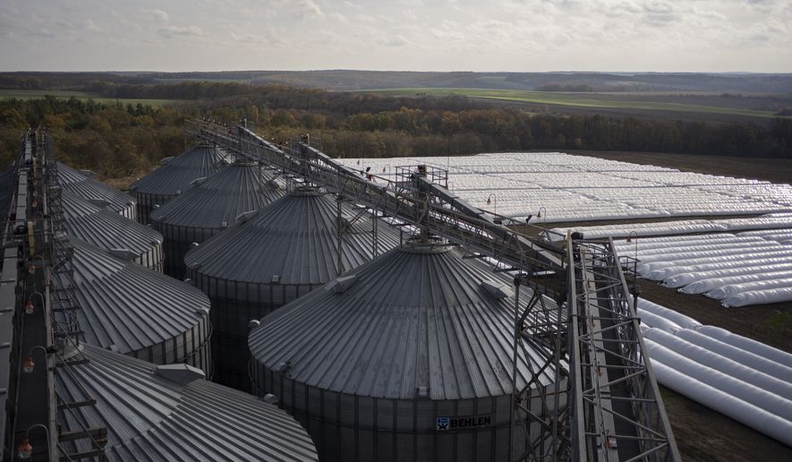 An overhead view of silos at a grain handling and storage facility in central Ukraine, Friday, Nov. 10, 2023. In recent months, an increasing amount of grain has been unloaded from overcrowded silos and is heading to ports on the Black Sea, set to traverse a fledgling shipping corridor launched after Russia pulled out of a U.N.-brokered agreement this summer that allowed food to flow safely from Ukraine during the war. (AP Photo/Hanna Arhirova)