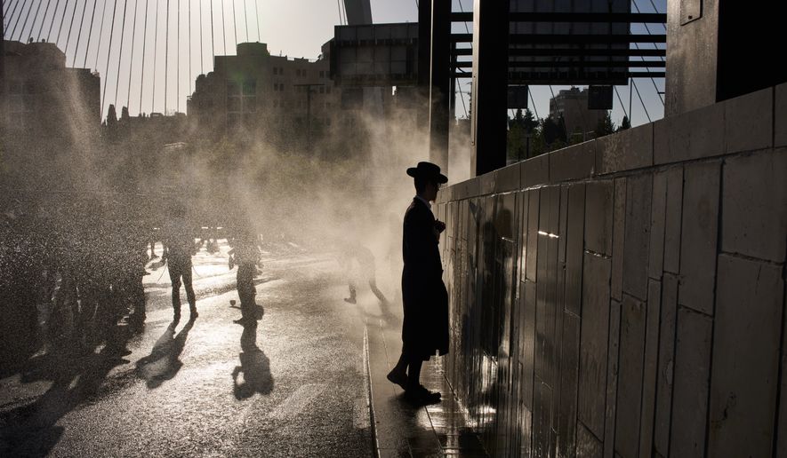 Police use a water cannon to disperse ultra-Orthodox Jewish men blocking a street during a protest against army recruitment in Jerusalem, Wednesday, April 29, 2026. (AP Photo/Leo Correa)