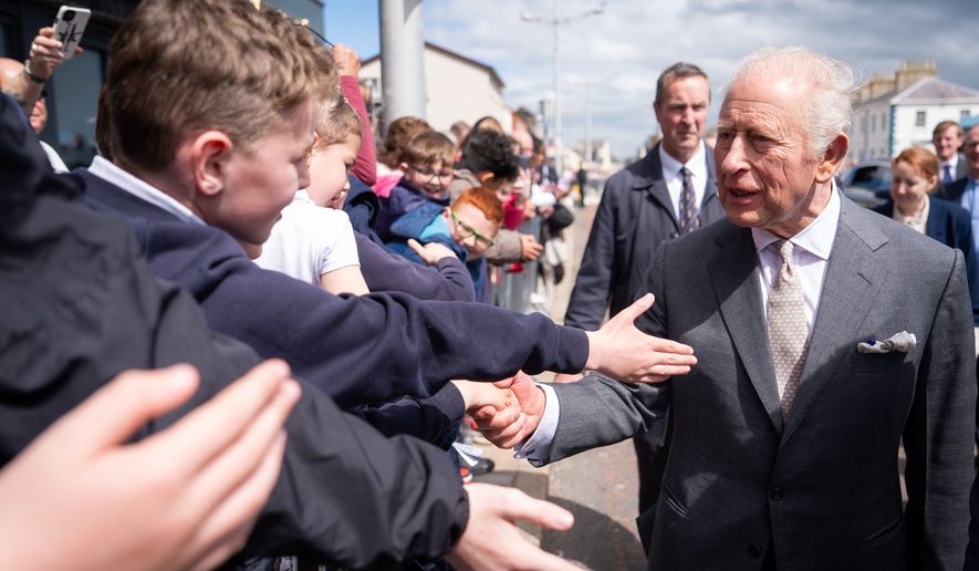 Britain's King Charles III, right, meets well-wishers outside The Pantry Foodbank in Donard Methodist Church, Newcastle, Northern Ireland, Wednesday, May 20, 2026. (Aaron Chown/PA via AP)
