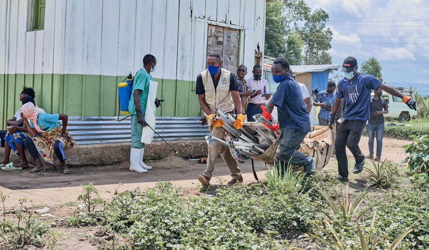 Aid workers carry supplies to set up an Ebola treatment center in Rwampara, Congo, Tuesday, May 19, 2026. (AP Photo/Dirole Lotsima Dieudonne) Corrects from Bunia to Rwampara.