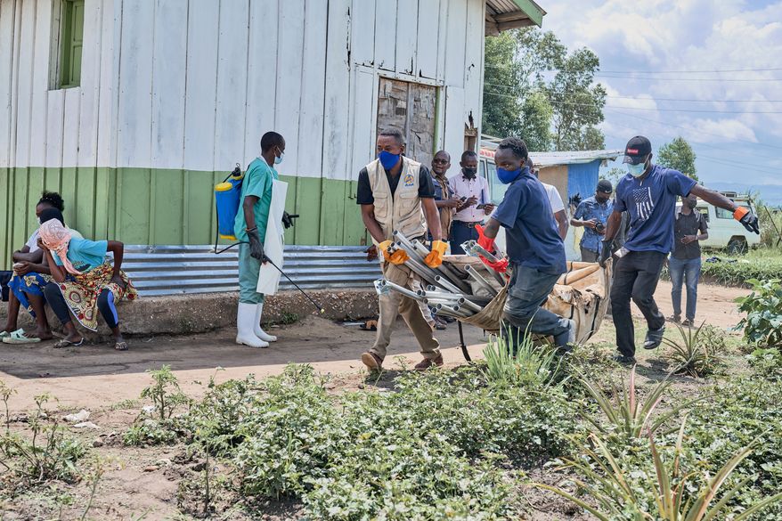 Aid workers carry supplies to set up an Ebola treatment center in Rwampara, Congo, Tuesday, May 19, 2026. (AP Photo/Dirole Lotsima Dieudonne) Corrects from Bunia to Rwampara.