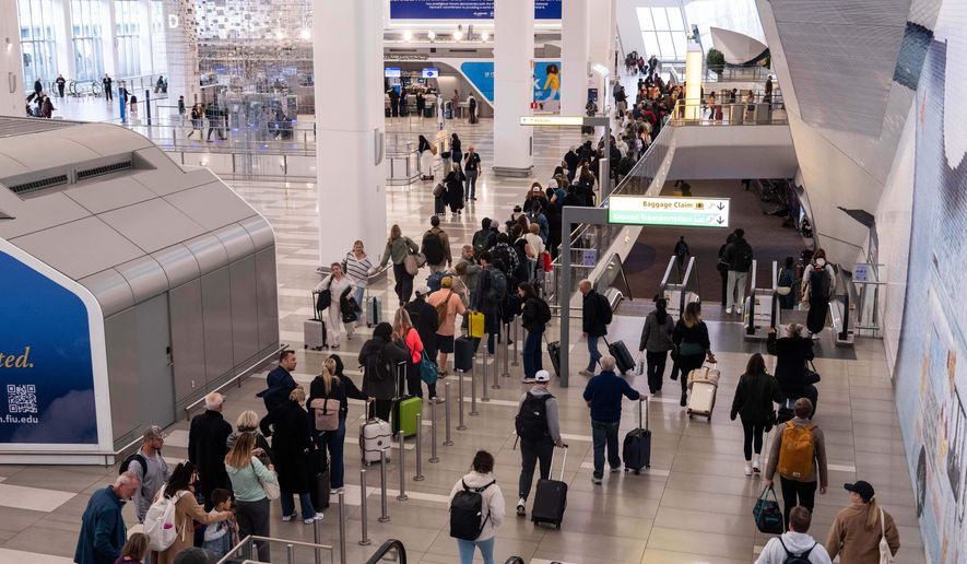 People wait in line at a Transportation Security Administration (TSA) security checkpoint at LaGuardia Airport in the Queens borough of New York, Nov. 9, 2025. (AP Photo/Adam Gray, File)