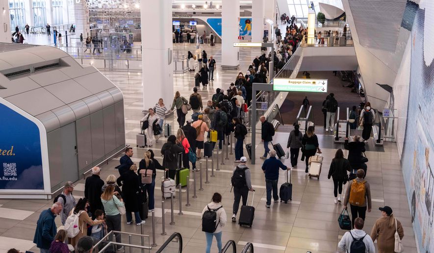 FILE - People wait in line at a Transportation Security Administration (TSA) security checkpoint at LaGuardia Airport in the Queens borough of New York, Nov. 9, 2025. (AP Photo/Adam Gray, File)