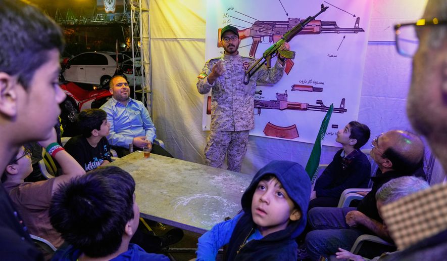 A member of the Revolutionary Guard's volunteer Basij force demonstrates how to handle a Kalashnikov-style assault rifle during a weapons training class in Tehran, Iran, Tuesday, May 19, 2026. (AP Photo/Vahid Salemi)
