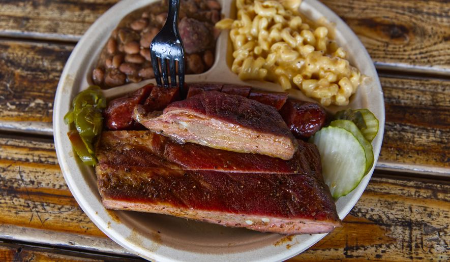 A plate of ribs and sausage with two sides is served at the Little Miss BBQ in Phoenix, Tuesday May 19, 2026. (AP Photo/Dario Lopez-Mills)
