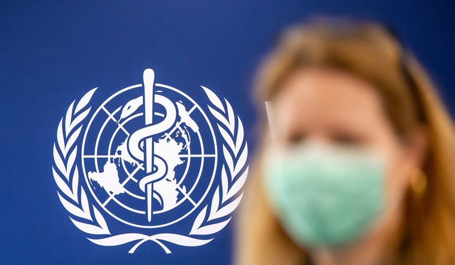 A person is wearing a protective face mask in front of the WHO logo, during the media regarding the epidemic of Ebola disease, during a press conference at the World Health Organization (WHO) headquarters in Geneva, Switzerland, Friday, May 22, 2026. (Martial Trezzini/Keystone via AP)
