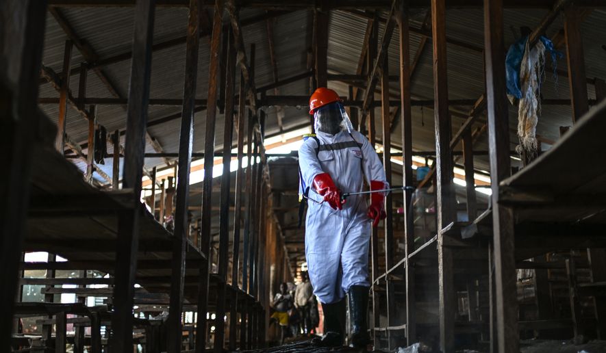 A sanitation worker from the Bunia city government sprays chlorine to disinfect the central market, as Ituri province continues to combat an Ebola outbreak, in Bunia, Congo, Saturday, May 23, 2026. (AP Photo/Moses Sawasawa)