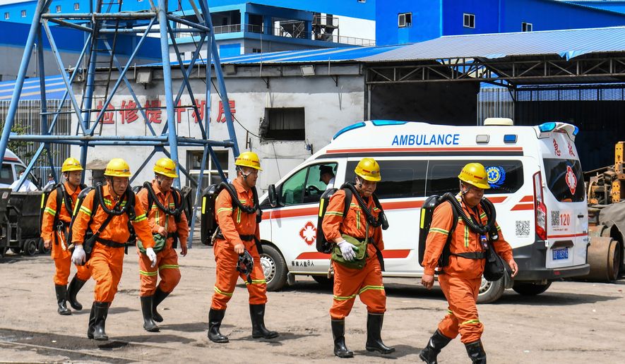 In this photo released by Xinhua News Agency, rescue workers pass by an ambulance in the aftermath of an explosion at Changzhi city's Liushenyu coal mine in Qinyuan county, northern China's Shanxi Province on Saturday, May 23, 2026. (Cao Yang/Xinhua via AP)