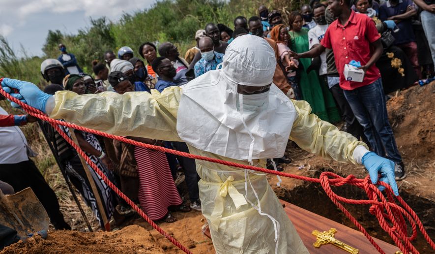Red Cross workers prepare a coffin containing the body of a Ebola victim for burial at the Rwampara Cemetery, in Bunia, Congo, Saturday, May 23, 2026. (AP Photo/Moses Sawasawa)