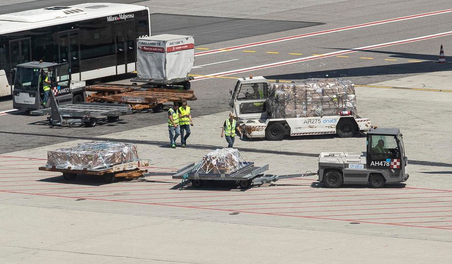 Coffins carrying the bodies of the divers who died in the Maldives arrive at Milan's Malpensa airport, Italy, Saturday, May 23, 2026. (Marco Ottico/LaPresse via AP)