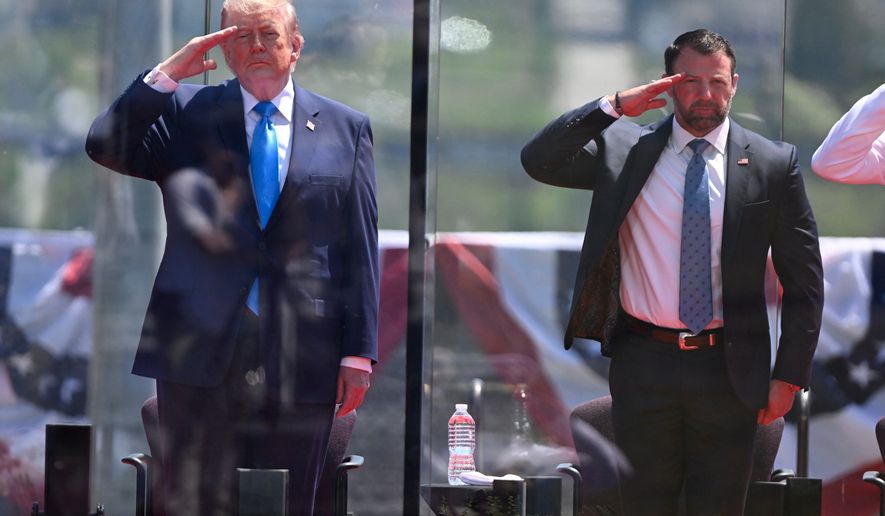 President Donald Trump, left, and Secretary of Homeland Security Markwayne Mullin, right, saluting at the start of the commencement ceremony at the U.S. Coast Guard Academy in New London, Conn., Wednesday, May 20, 2026. (AP Photo/Jessica Hill)