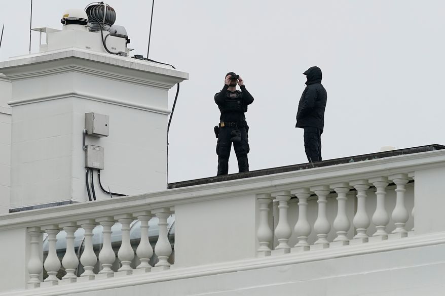 U.S. Secret Service Police observe from the roof of the White House, Saturday, May 23, 2026, in Washington, after reports of shots fired near the White House. (AP Photo/Jose Luis Magana)