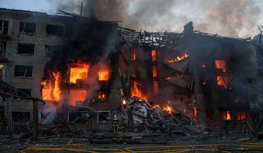 Rescue workers try to put out a fire at a residential building after a Russian strike on Kyiv, Ukraine, Sunday, May 24, 2026. (AP Photo/Evgeniy Maloletka)