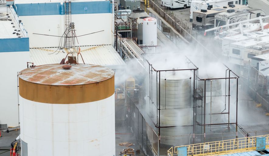 Water is sprayed on a damaged tank at GKN Aerospace in Garden Grove, Calif., on Sunday, May 24, 2026, after the tank containing a chemical used to make plastic parts overheated Thursday. (AP Photo/Ethan Swope)