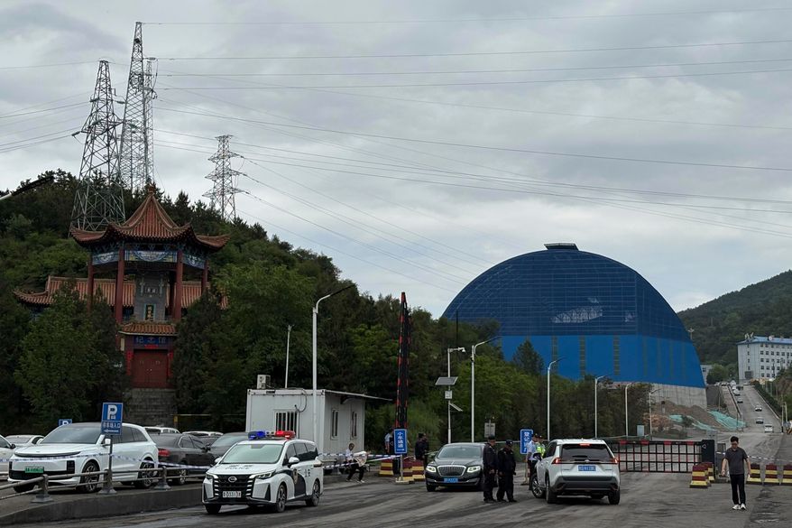 Police officers at a checkpoint stop cars at the entrance to the Liushenyu coal mine facility in Qinyuan county in Changzhi, northern China's Shanxi province on Sunday, May 24, 2026. (AP Photo/E. Eduardo Castillo)