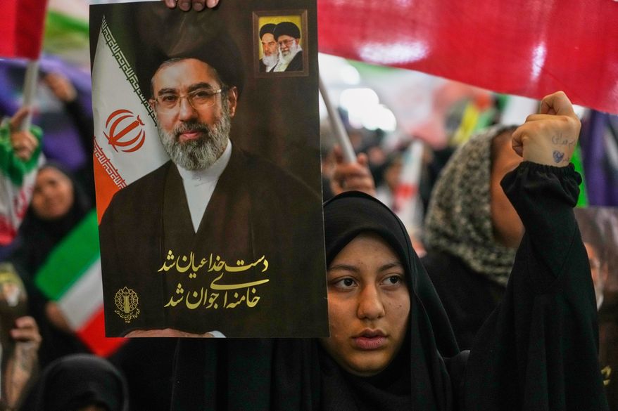 A woman holds a portrait of Iran's Supreme Leader Ayatollah Mojtaba Khamenei, during a ceremony honoring the armed forces and those killed in the war with Israel and the U.S. at the Imam Khomeini Grand Mosque in Tehran, Iran, Sunday, May 24, 2026. (AP Photo/Vahid Salemi)