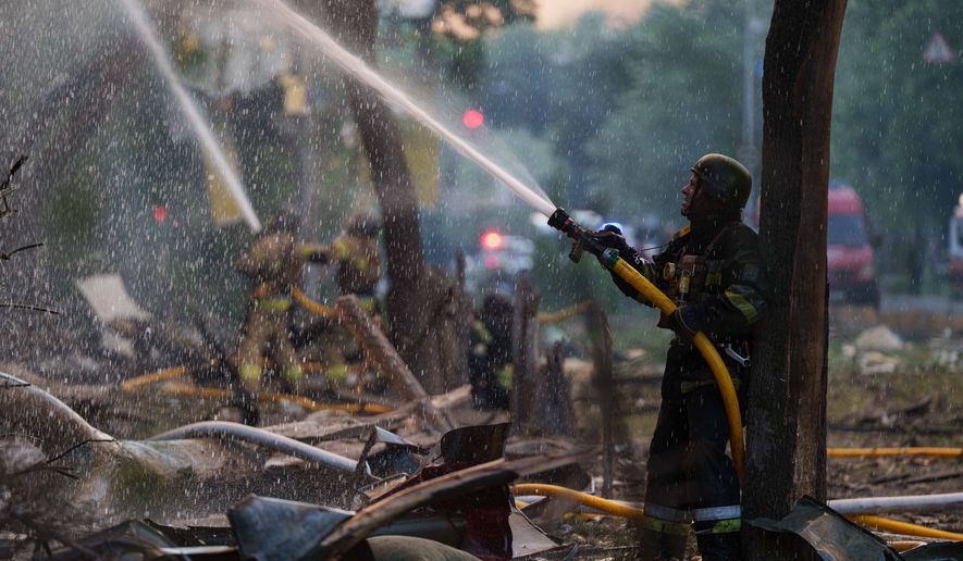 Rescue workers try to put out a fire at a residential building after a Russian strike on Kyiv, Ukraine, on Sunday, May 24, 2026. (AP Photo/Evgeniy Maloletka)