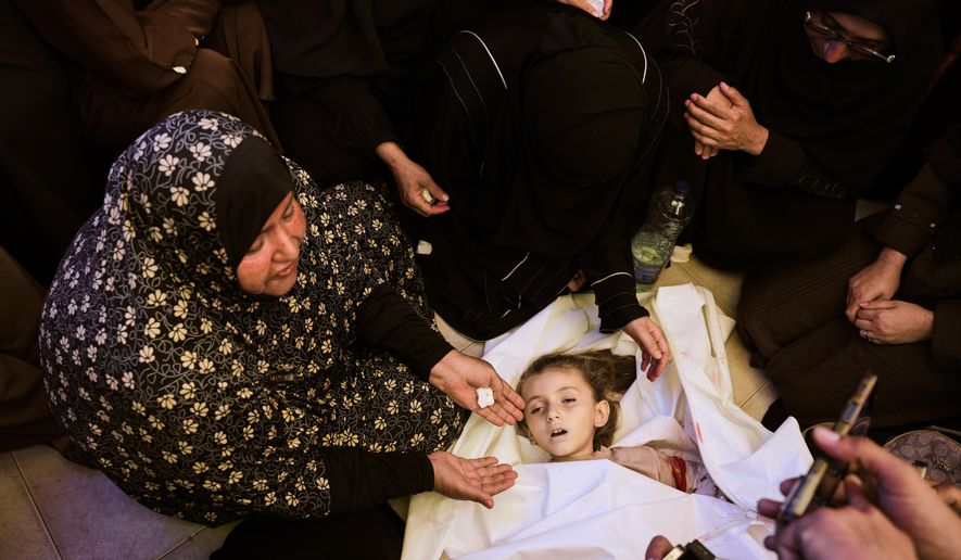 Relatives mourn around the body of 6-year-old Palestinian girl Menna Allah Abu Labda, who was killed in an Israeli airstrike, during her funeral at Nasser Hospital in Khan Younis, Gaza Strip, Monday, May 25, 2026. (AP Photo/Abdel Kareem Hana)