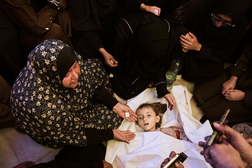 Relatives mourn around the body of 6-year-old Palestinian girl Menna Allah Abu Labda, who was killed in an Israeli airstrike, during her funeral at Nasser Hospital in Khan Younis, Gaza Strip, Monday, May 25, 2026. (AP Photo/Abdel Kareem Hana)