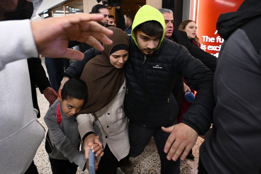 A group of supporters surrounds a woman and child with alleged ties to the Islamic State as they arrive at Melbourne International Airport, in Melbourne, Australia, Thursday, May 7, 2026. (Joel Carrett/AAP Image via AP, File)
