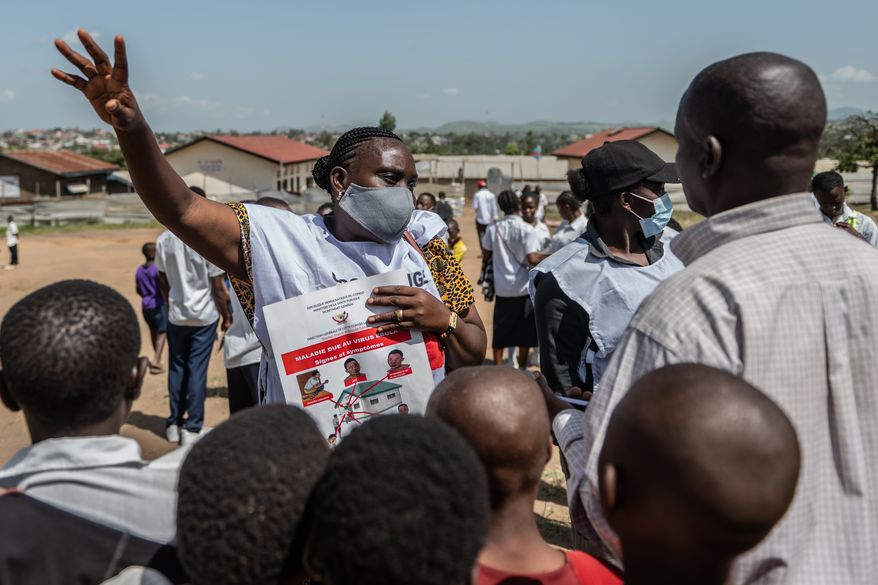 Vanny Birungi, a Red Cross volunteer, speaks to people during a public sensitisation campaign amid the Ebola outbreak in Bunia, Congo, Monday, May 25, 2026. (AP Photo/Moses Sawasawa)