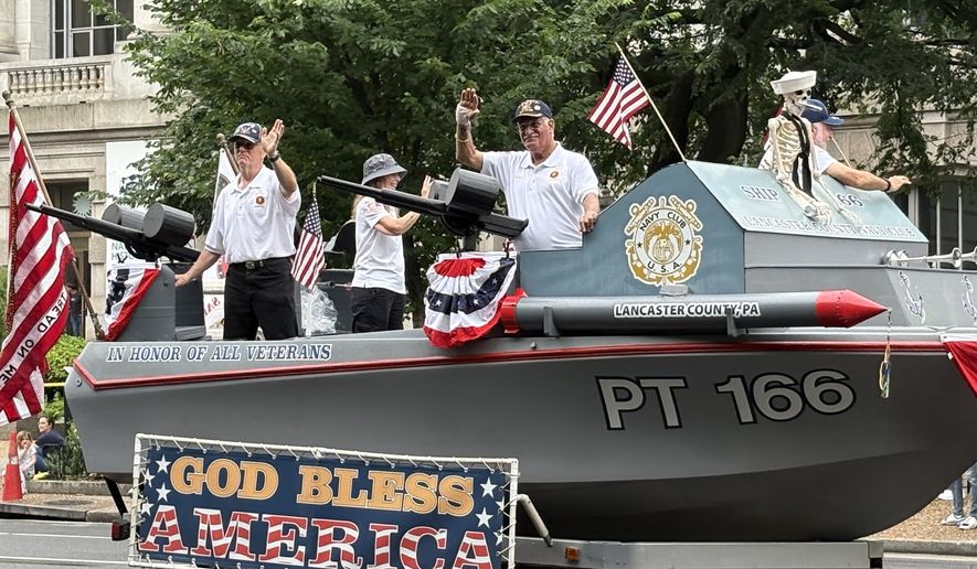 Members of the Lancaster County Navy Club in Pennsylvania greet paradegoers as their float drifts by near the National Museum of American History. (Matt Delaney/The Washington Times)