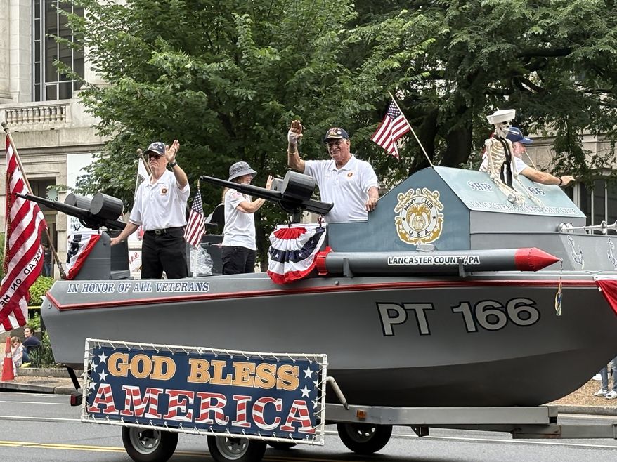 Members of the Lancaster County Navy Club in Pennsylvania greet paradegoers as their float drifts by near the National Museum of American History. (Matt Delaney/The Washington Times)