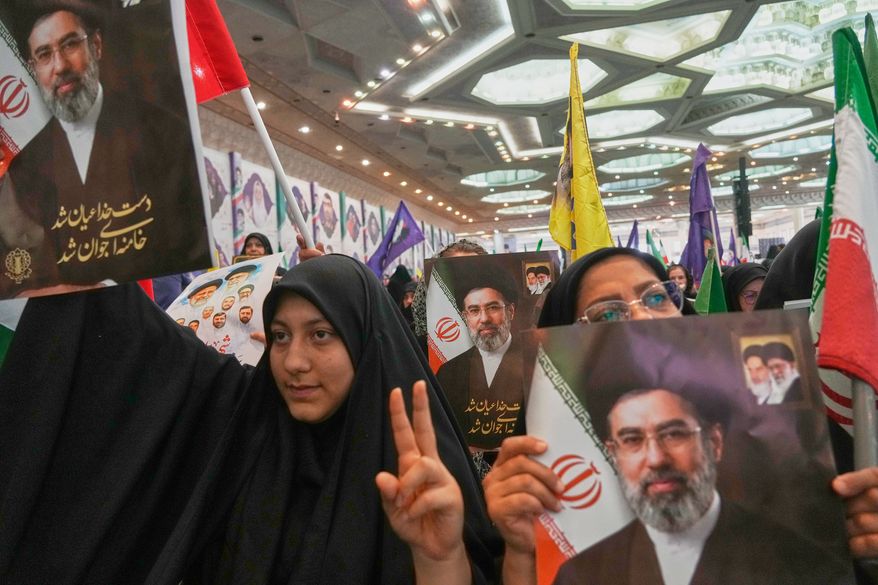 Women hold portraits of Iran's Supreme Leader, Ayatollah Mojtaba Khamenei, during a ceremony honoring the armed forces and those killed in the war with Israel and the U.S. at the Imam Khomeini Grand Mosque in Tehran, Iran, Sunday, May 24, 2026. (AP Photo/Vahid Salemi)