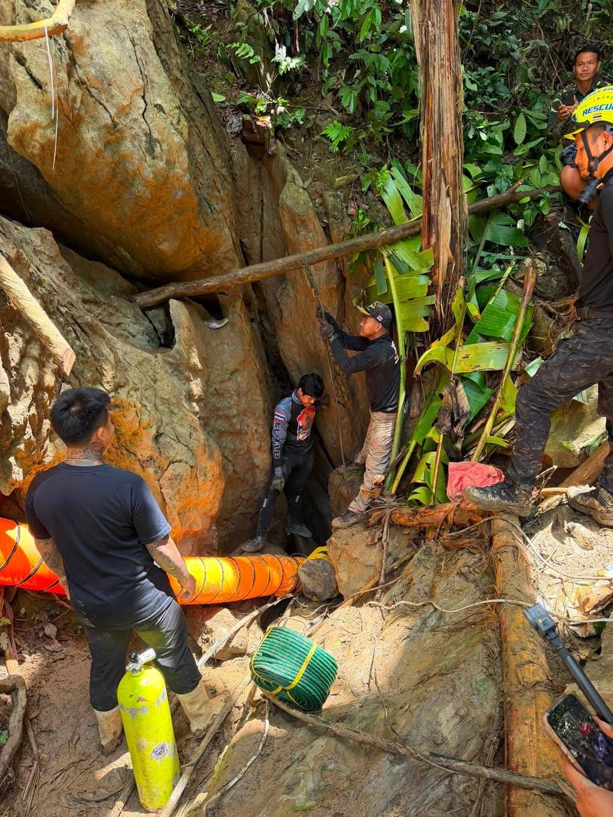 In this release Metta Tham Rescue Kalasin, rescuers work to reach seven people who have been trapped in a cave in Xaisomboun province, Laos, Monday, May 25, 2026. (Metta Tham Rescue Kalasin via AP)