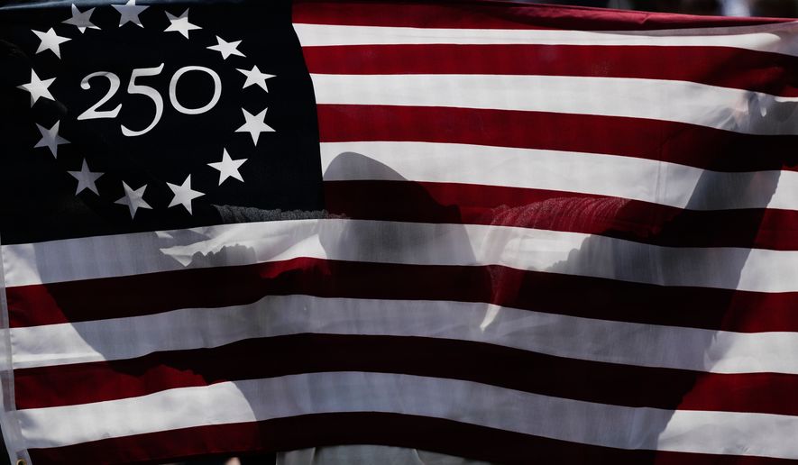 A baseball fan holds a flag for Memorial Day after first inning of a baseball game between the Minnesota Twins and the Chicago White Sox in Chicago, Monday, May 25, 2026. (AP Photo/Nam Y. Huh)