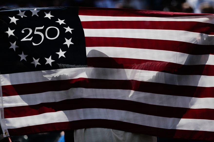 A baseball fan holds a flag for Memorial Day after first inning of a baseball game between the Minnesota Twins and the Chicago White Sox in Chicago, Monday, May 25, 2026. (AP Photo/Nam Y. Huh)