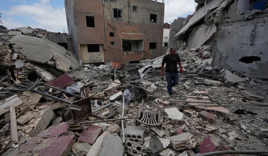 A man walks between destroyed buildings that were hit in Israeli airstrikes in Burj al-Shemali village near the southern port city of Tyre, Lebanon, Tuesday, May 26, 2026. (AP Photo/Mohammed Zaatari)