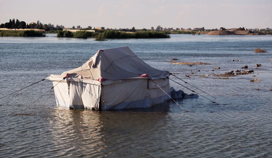 A tent belonging to displaced residents stands partially submerged in floodwaters along the banks of the Euphrates River near Raqqa, northeastern Syria, Tuesday, May 26, 2026. (AP Photo/Baderkhan Ahmad)