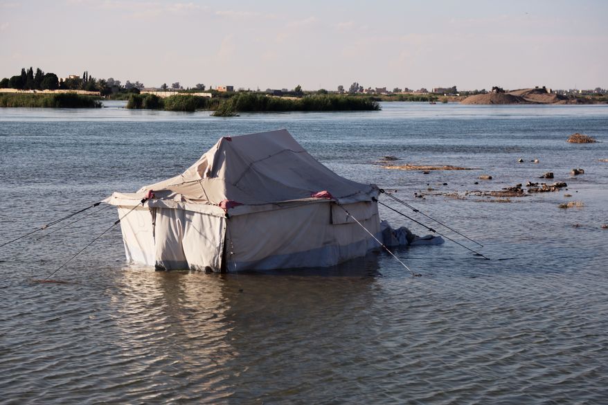 A tent belonging to displaced residents stands partially submerged in floodwaters along the banks of the Euphrates River near Raqqa, northeastern Syria, Tuesday, May 26, 2026. (AP Photo/Baderkhan Ahmad)