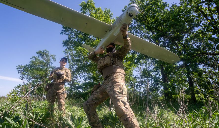 Ukrainian servicemen of Khartia brigade launch a drone towards Russian positions at the front line in the Kharkiv region, Ukraine, Wednesday, May 20, 2026. (AP Photo/Andrii Marienko)