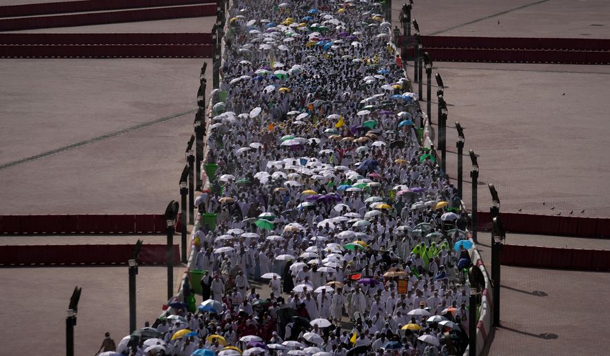 Muslim pilgrims walk on their way to cast pebbles at pillars in the symbolic stoning of the devil, the last rite of the annual Hajj, in Mina near the holy city of Mecca, Saudi Arabia, Wednesday, May 27, 2026. (AP Photo/Altaf Qadri)