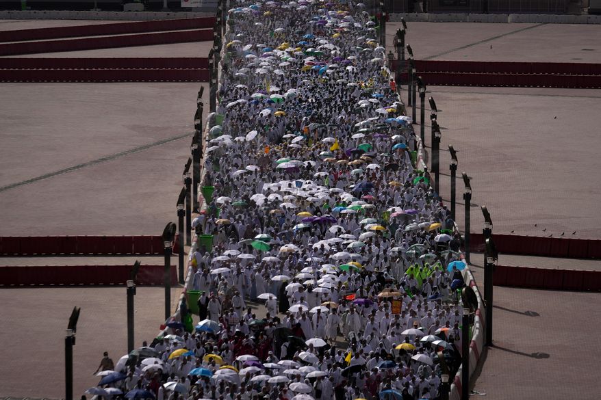 Muslim pilgrims walk on their way to cast pebbles at pillars in the symbolic stoning of the devil, the last rite of the annual Hajj, in Mina near the holy city of Mecca, Saudi Arabia, Wednesday, May 27, 2026. (AP Photo/Altaf Qadri)