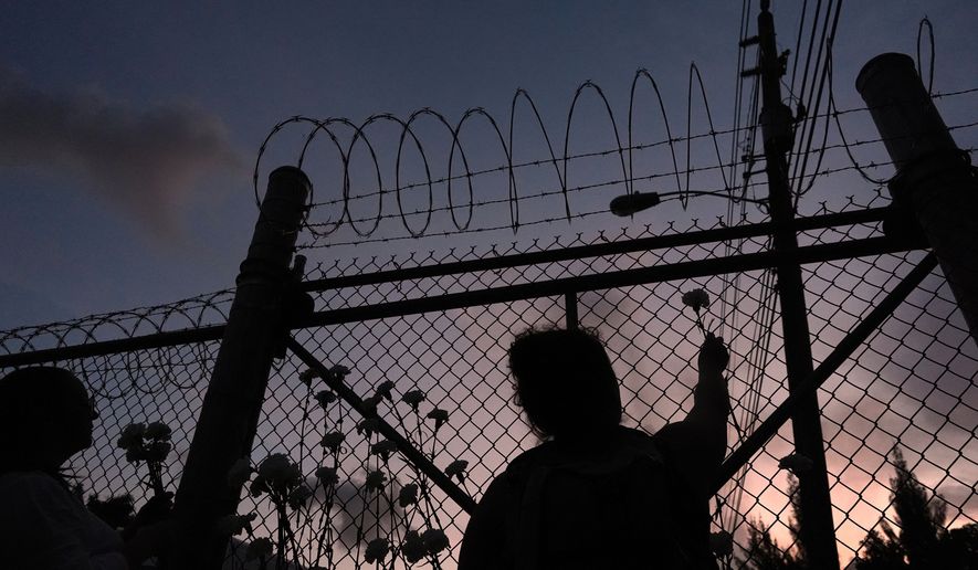 People place flowers on a fence outside Krome Detention Center in Miami on Saturday, May 24, 2025, during a vigil to recognize people who have died in U.S. Immigration and Customs Enforcement custody as well as those affected by mass deportations. (AP Photo/Rebecca Blackwell) **FILE**