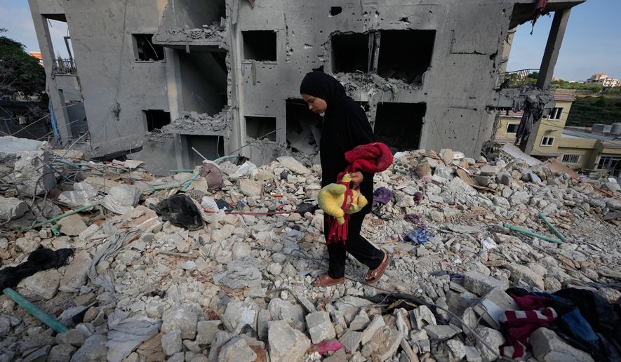 A resident carries belongings as she walks through the rubble of her home destroyed in an Israeli airstrike a day earlier in the southern village of Maarakeh, Lebanon, Wednesday, May 27, 2026. (AP Photo/Mohammed Zaatari)